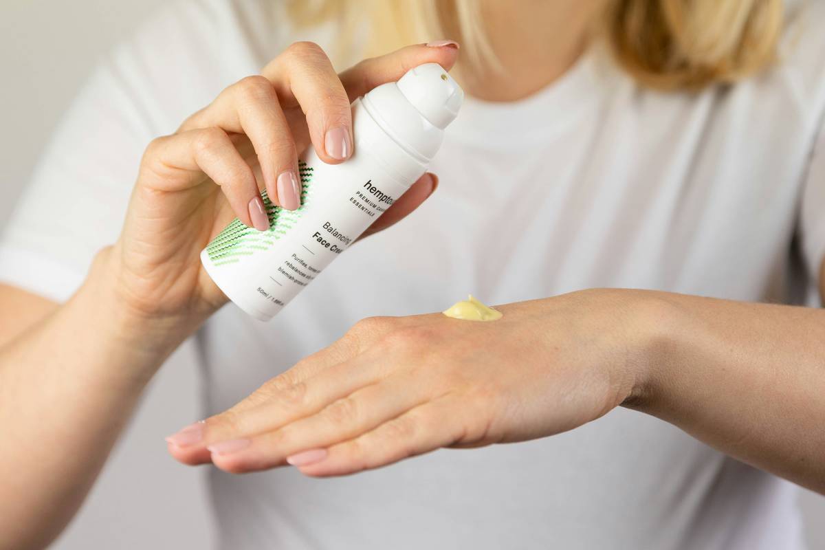 woman applying rich moisturizer butter body cream mature skin on arms
